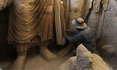 An Afghan archaeologist looks at Buddha statues at Mes Aynak.